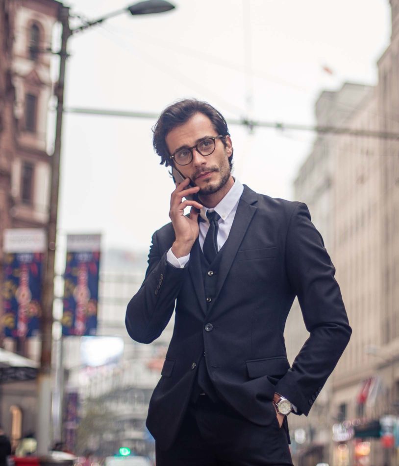 Confident man downtown talking on phone wearing a suit