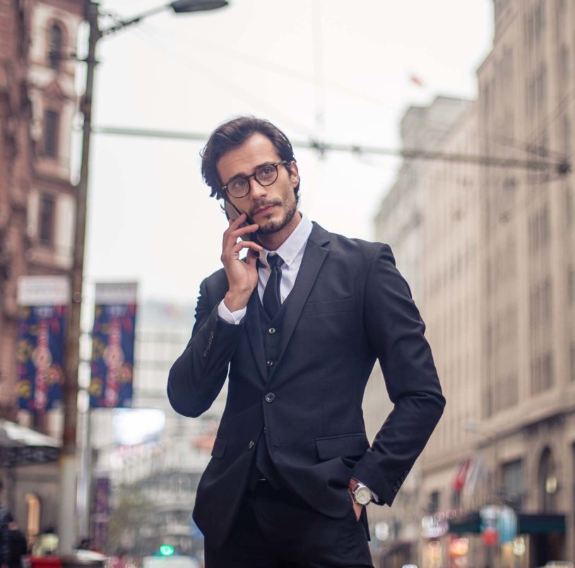 Confident man downtown talking on phone wearing a suit