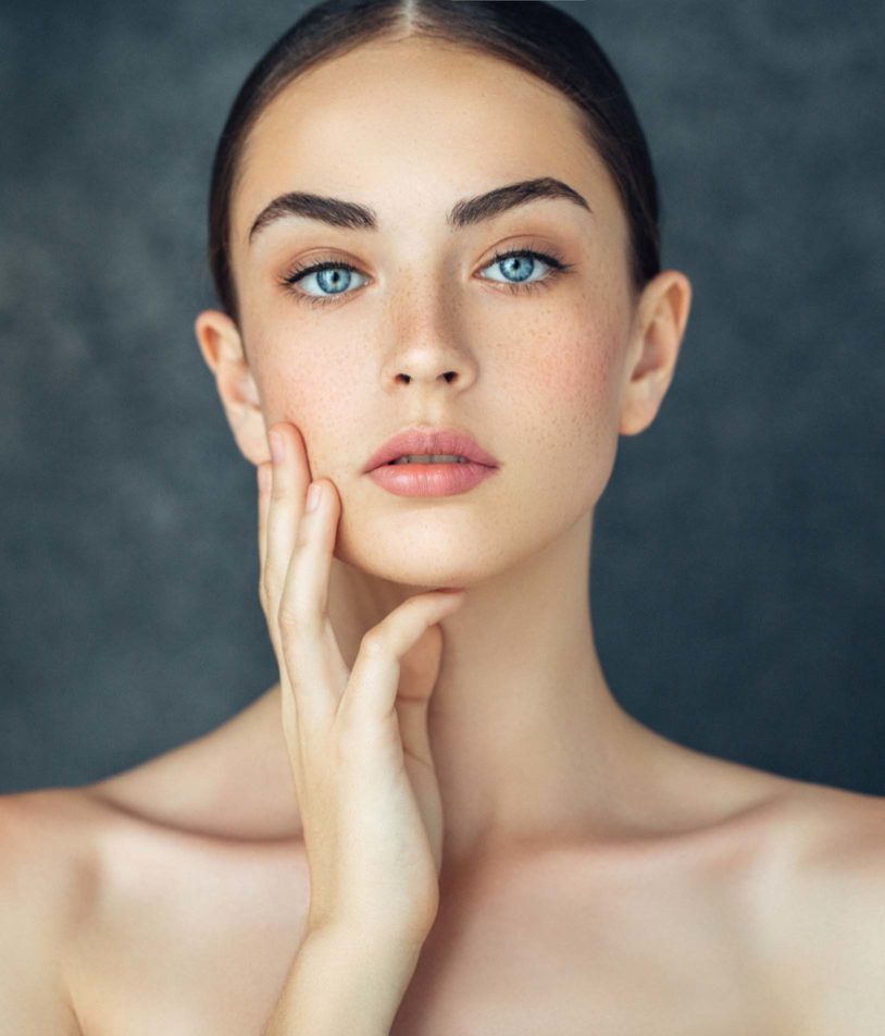 Blue eyed woman with freckles showing her perfect face