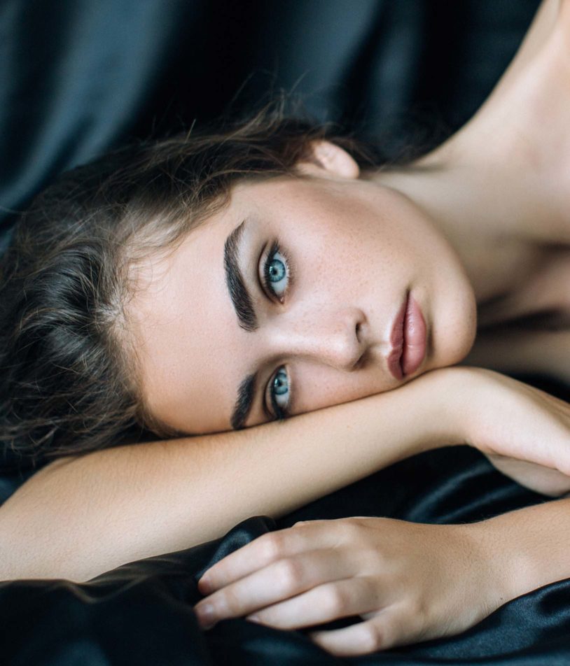 Blue eyed and perfect eyebrow woman laying down