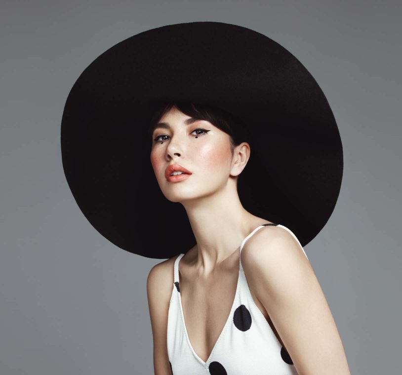 Asian woman posing with a big black hat