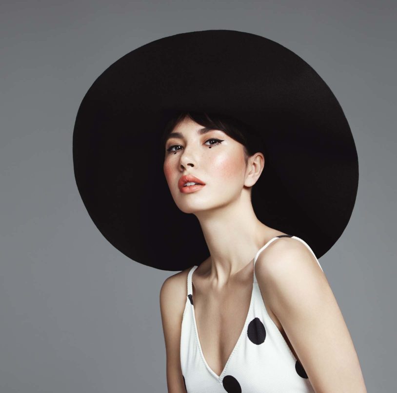Asian woman posing with a big black hat