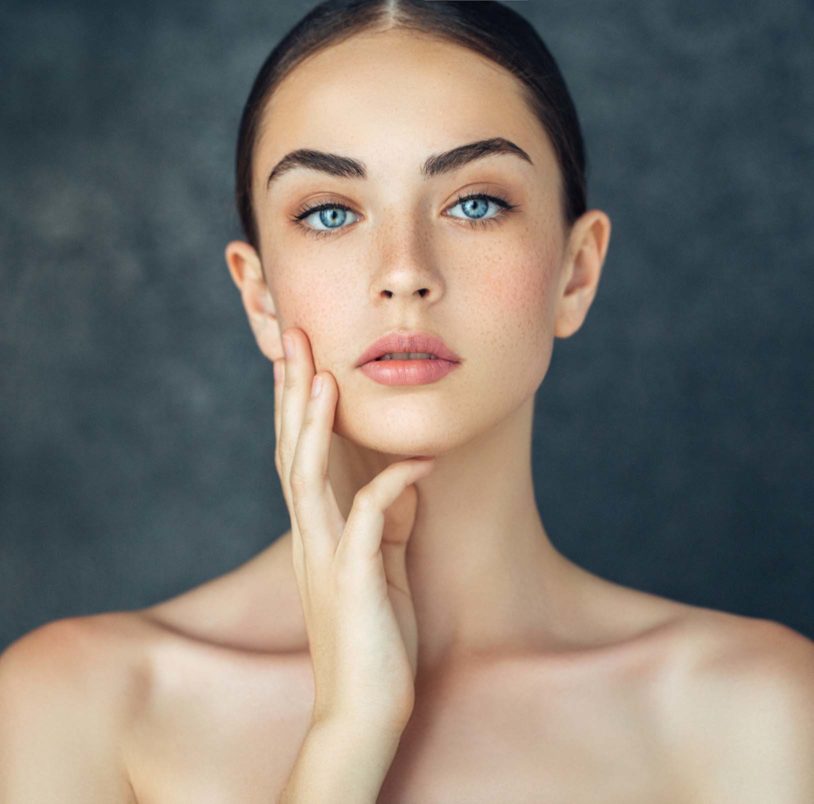 Blue eyed woman with freckles showing her perfect face