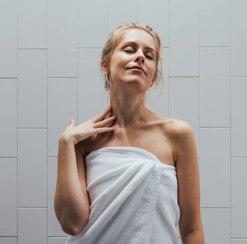 A woman just out of the shower wrapped in a towel